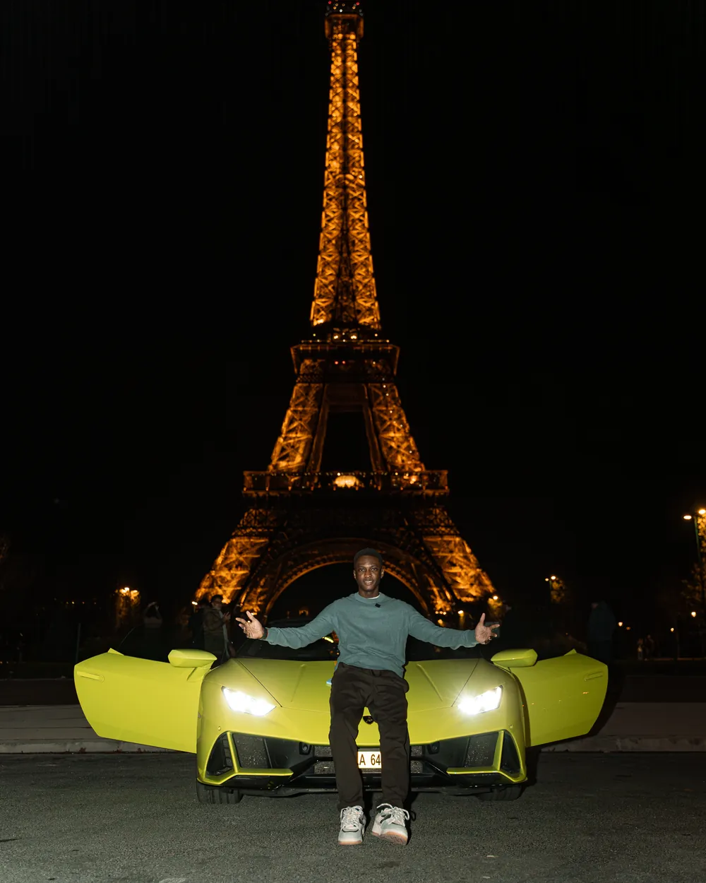 Wilson BOTOYIYE à Paris, devant la tour Eiffel illuminée.