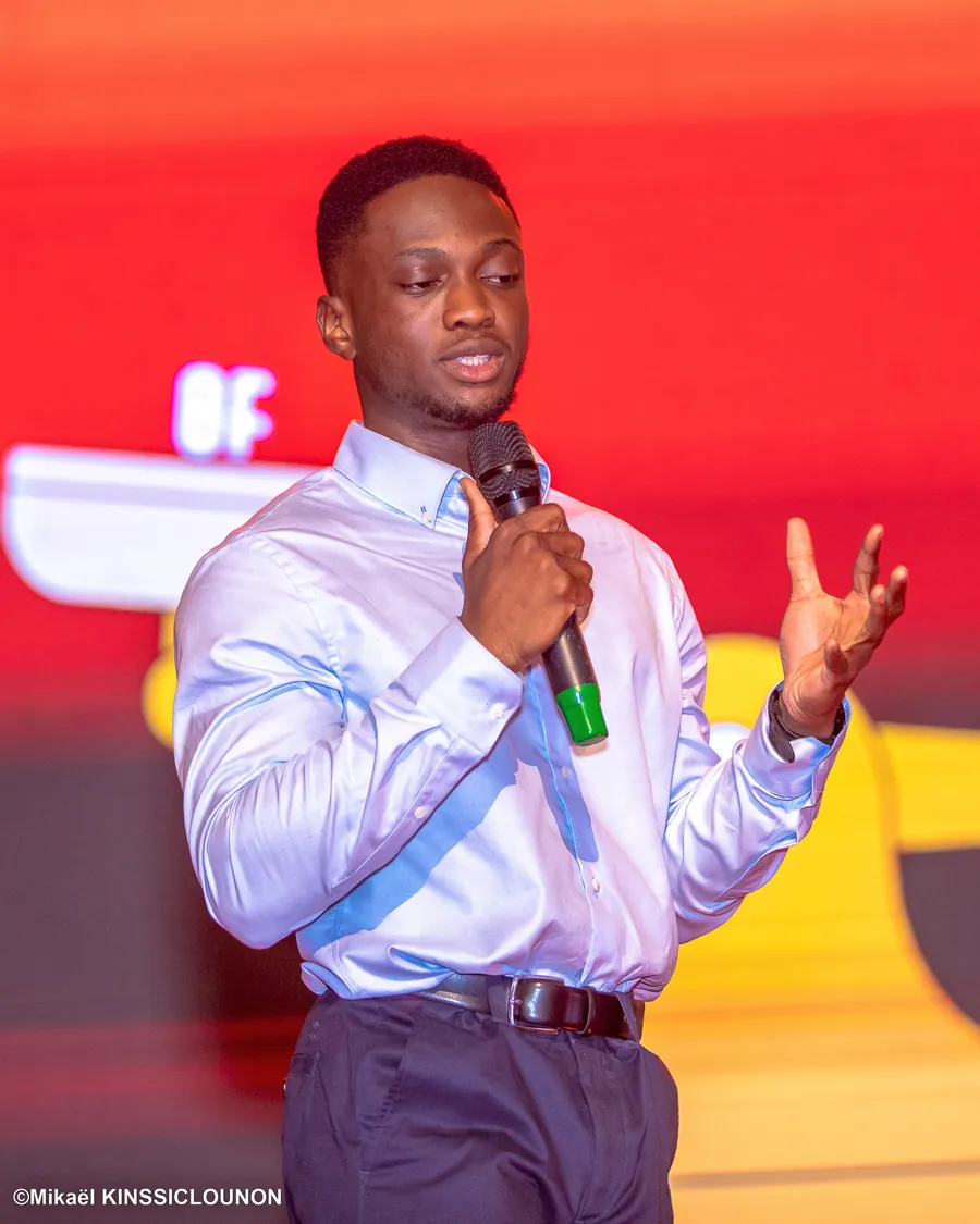 Wilson BOTOYIYE, micro en main, sur la scène du Summit de Cotonou.