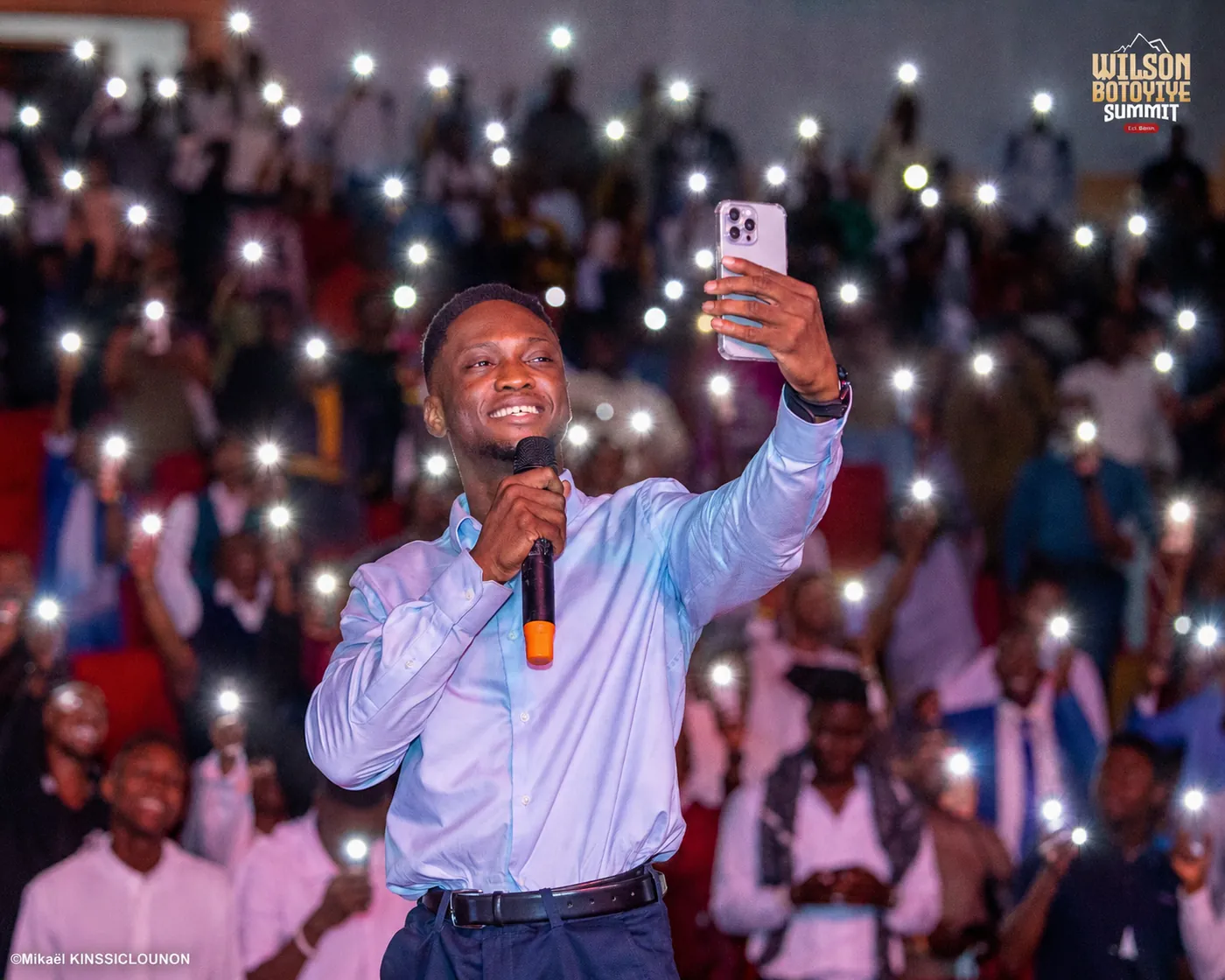 Wilson BOTOYIYE prend un selfie avec le public, téléphones allumés, au Summit de Cotonou.